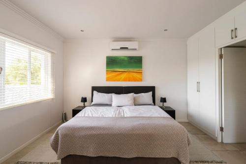 a bedroom with a bed and a painting on the wall at Casa Casa - Studio in Durban