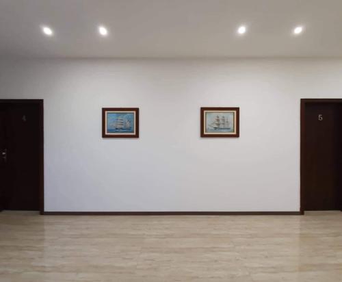 two framed pictures on a white wall in a room at Il Galeone hotel in Stupava