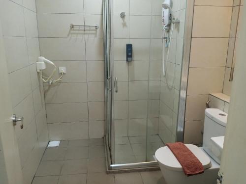 a bathroom with a shower and a toilet at The Octagon Ipoh - Home Stay in Ipoh