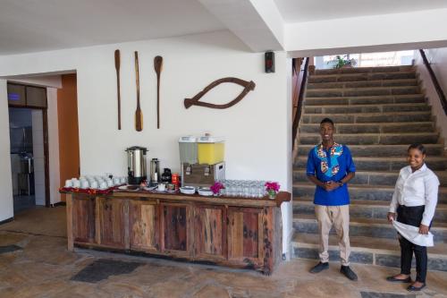 twee mannen staan naast een balie in een kamer bij Reef & Beach Resort - Spa Jambiani in Jambiani