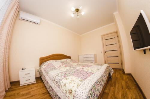 a bedroom with a bed and a dresser and a tv at ATLANT Apartments 213 in Voronezh