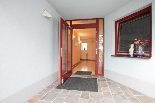 an open door with a vase of flowers in a window at Studiowohnungen am Rieger-Hof in Hartmannsdorf