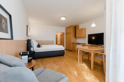 ein Wohnzimmer mit einem Bett und einem Esszimmer in der Unterkunft Studiowohnungen am Rieger-Hof in Hartmannsdorf