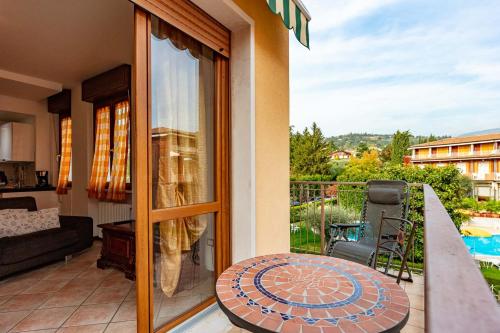 balkon z widokiem na patio ze stołem w obiekcie La Cà del Picia w mieście Garda