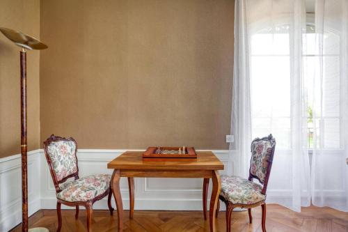 ein Esszimmer mit einem Tisch und 2 Stühlen in der Unterkunft Le Clos des Pervenches in Jassans-Riottier
