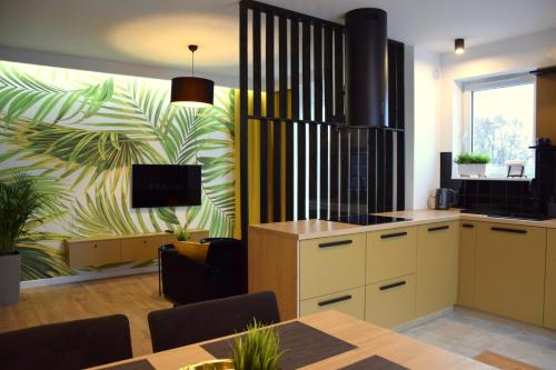a kitchen and dining room with a table and a tv at W&K Apartments - Gold Suite in Koszalin