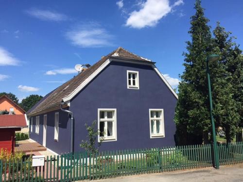 ein lila Haus mit einem Zaun davor in der Unterkunft Ferienhaus Niemtsch in Niemtsch