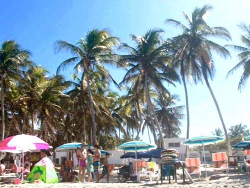 a group of people on a beach with palm trees at Hotel Costa Linda Beach in La Loma