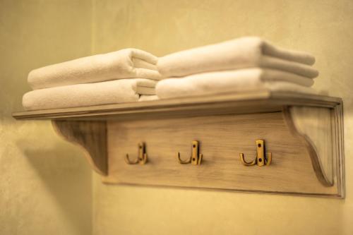 a wooden shelf with towels on it in a bathroom at Magus Hotel in Baia Mare