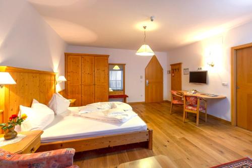 a bedroom with a bed and a table in a room at Steinegger Eppan in Appiano sulla Strada del Vino