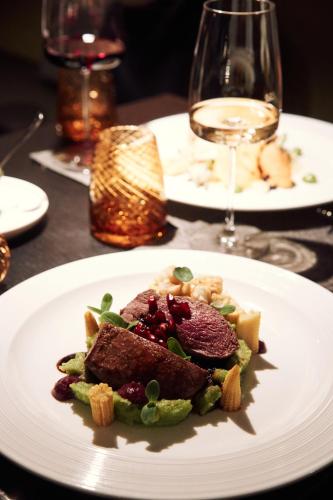a plate of food on a table with wine glasses at WunnersWat Verl in Verl
