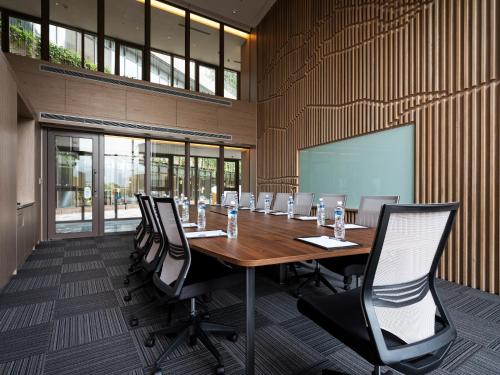 a conference room with a long wooden table and chairs at Fame Hall Garden Hotel in Longtan