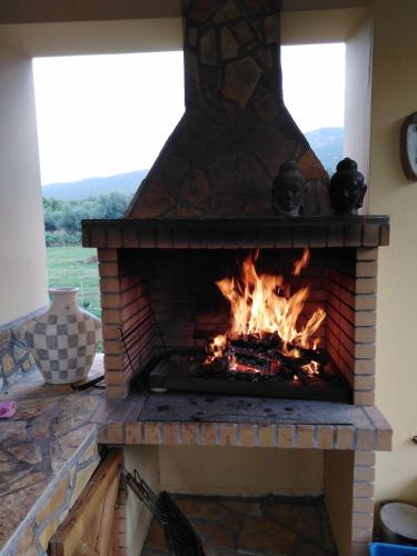 a brick fireplace with a fire in it at Villa Porto Matzavino in Vonitsa