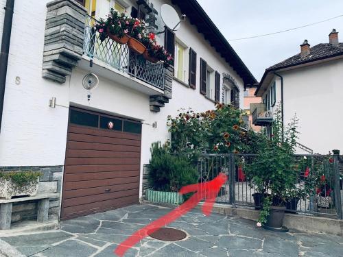 ベリンツォーナにあるCasa Nataliya, via tampori 8 6503 Bellinzonaの赤いリボンが付いたガレージのある家