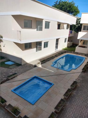 um edifício com duas piscinas em frente a um edifício em Zapipou - Apartamento aconchegante para você aproveitar o melhor de Pipa em Pipa