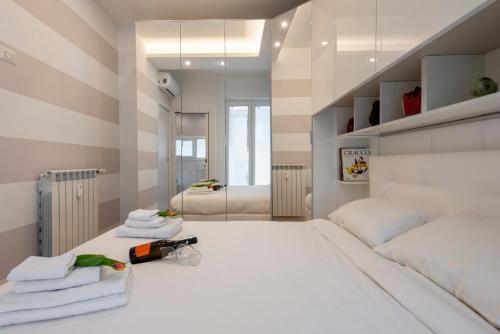 ein Schlafzimmer mit einem großen weißen Bett und Handtüchern in der Unterkunft BnButler Friuli, 24 - Porta Romana Apartment in Mailand
