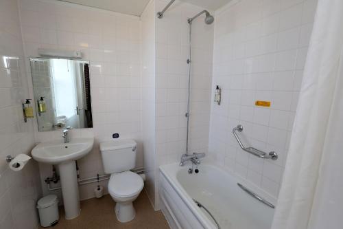 a bathroom with a toilet and a sink and a tub at Shore View Hotel in Eastbourne
