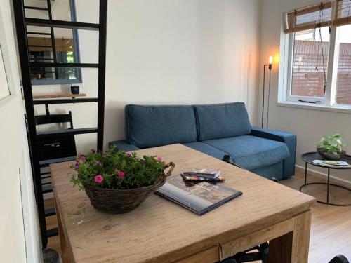 a living room with a blue couch and a table at Pelican Dune near the beach. in Noordwijk aan Zee