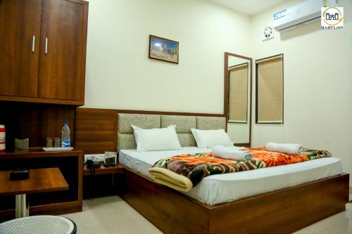 a bedroom with a bed with a wooden headboard at HOTEL BABYLON REGENCY, Opp Krishna Janmabhoomi Temple in Mathura