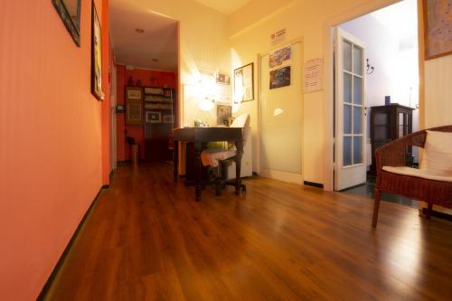 corridoio con pavimento in legno e tavolo in una stanza di Il Riposo del Guerriero Guesthouse a Genova