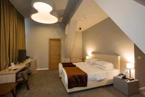 a bedroom with a bed and a desk and a sink at Best Western Premier Ark Hotel in Tirana