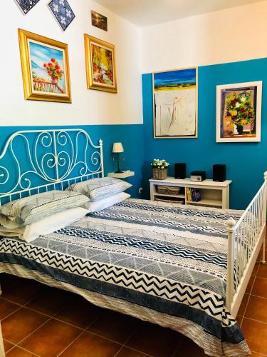 a bed in a room with blue walls and paintings at VILLA "Casa al Chiazzullo" in Mirabella Eclano