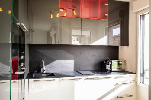 d'une cuisine avec des placards blancs et un plafond rouge. dans l'établissement Krystal Palace A, à Beausoleil