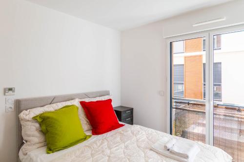 - une chambre dotée d'un lit avec des oreillers verts et rouges dans l'établissement Krystal Palace A, à Beausoleil