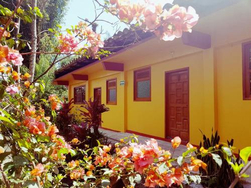 una casa amarilla con flores delante en Meson Yohualichan, en Cuetzalán del Progreso