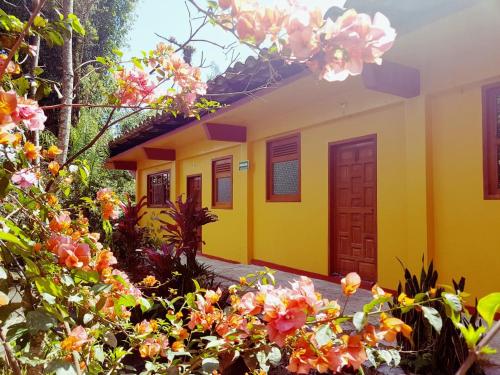a yellow house with flowers in front of it at Meson Yohualichan in Cuetzalán del Progreso