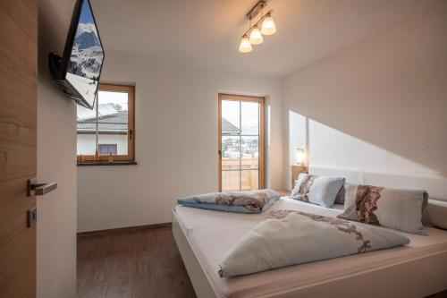 a bedroom with a bed and a window at Appartements Höpfl in Westendorf