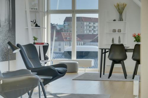 a room with chairs and a table and a window at Harbour Penthouse in Sønderborg