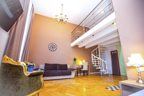 a living room with a couch and a staircase at Rustaveli Hotel in Tbilisi City