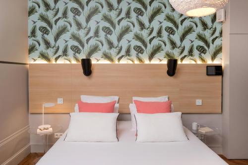 a bedroom with two beds and a wall with a mural at MiHotel Gailleton in Lyon