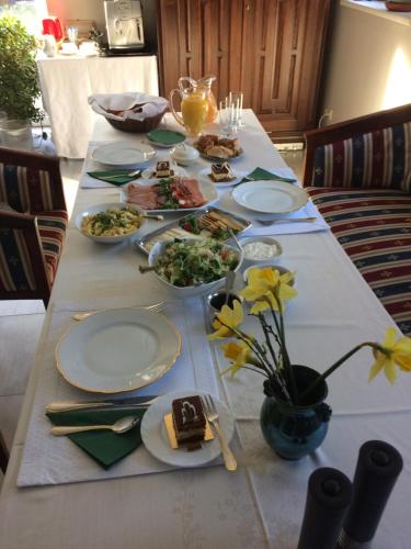 een lange tafel met borden met eten erop bij Classic Car Museum Apartment in Rīga
