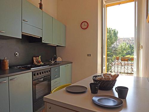 una cucina con armadi verdi e un tavolo con piatti di Casa Ariodante a Perugia