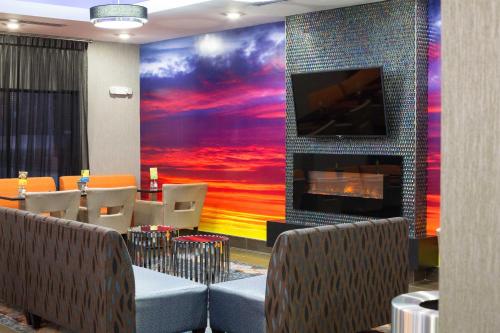 a restaurant with a fireplace and a tv on a wall at Holiday inn Express & Suites Oklahoma City Southeast by IHG in Oklahoma City
