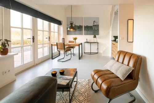 uma sala de estar com um sofá e uma mesa em Saenliefde em Wormer