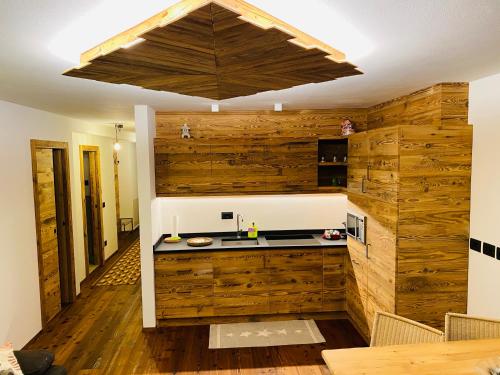 - une cuisine avec des murs en bois et un comptoir dans l'établissement Cèsa Mia, à Campitello di Fassa