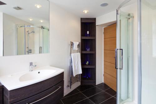 a bathroom with a sink and a shower at Queens Mansions: Duchess Suite in Blackpool