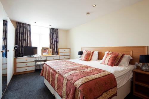 Habitación de hotel con cama grande y escritorio. en Queens Mansions: Duchess Suite, en Blackpool