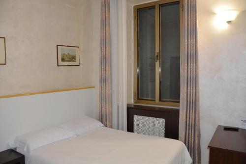 a small bedroom with a bed and a window at Roma Carina in Rome