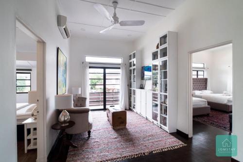 a white room with a bedroom and a bed and a couch at Jomstay Mayhaven Villa (Ipoh) in Ipoh