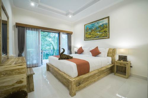 a bedroom with a bed and a large window at Adenia House Ubud in Ubud