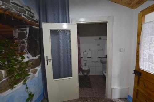 a bathroom with a toilet and a white door at Casa Murroni in Pau