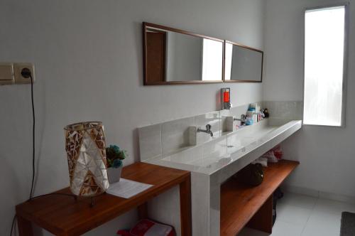 a bathroom with a sink and a mirror on the wall at Askara Guest House & Hostel in Ubud