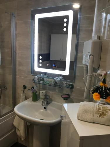 a bathroom with a sink and a mirror at Purple Suite in Sinaia