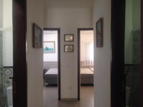 un corridoio con 2 letti e una porta che conduce a una camera da letto di Village com 4 APTOS PÉ NA AREIA E PISCINA a São Sebastião