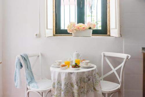a table with two chairs and two glasses of orange juice at Romantic - Casa Rua Bela in Porto