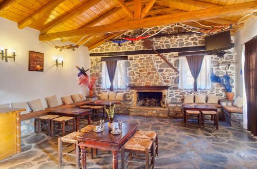 a room with tables and a stone fireplace at Guesthouse Toxotis in Pirgos Dhirou